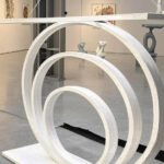 The Modern Concentric Ring Sculpture with Figurines is a bold, hangable art piece featuring suspended concentric rings and minimal figurines